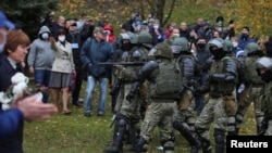 Сілавікі настаўляюць зброю на мірных пратэстоўцаў. Менск, Курапаты, 1 лістапада 2020. Фота Reuters