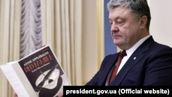 Президент Украины Петр Порошенко листает книгу Энн Эпплбаум «Красный голод: Война Сталина против Украины»