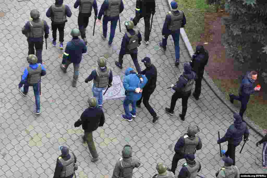 На гэтым фота і ніжэй меркавана супрацоўнікі ГУБАЗіК зьбіваюць і хапаюць людзей у пачатку праспэкту Пераможцаў