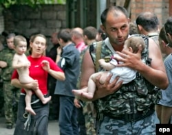 Один из самых знаменитых снимков, сделанный во время теракта в Беслане. Военный выносит грудного ребенка, которого боевики отдали после переговоров с Русланом Аушевым. 2 сентября 2004 года