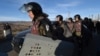 Kazakhstan - Kordai - Korday - Police officers walk on a road outside the village of Masanchi some 250 km from Almaty on February 8, 2020. - Eight people were killed, dozens hurt and property burned during clashes between ethnic Kazakhs and members of the